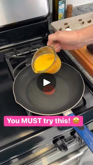 a person pouring orange juice into a frying pan on top of an open stove