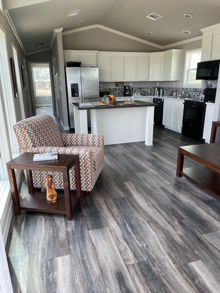 a kitchen and living room with wood flooring