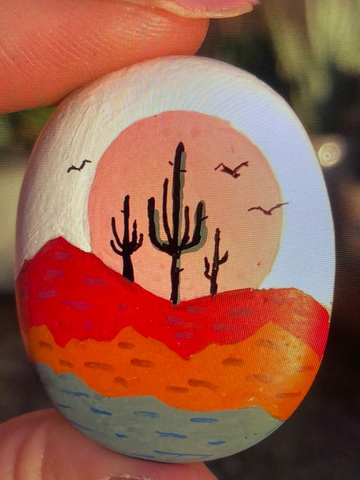 a painted rock with a desert scene on it