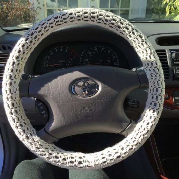 the steering wheel cover is made out of knitted material and has an intricate design on it