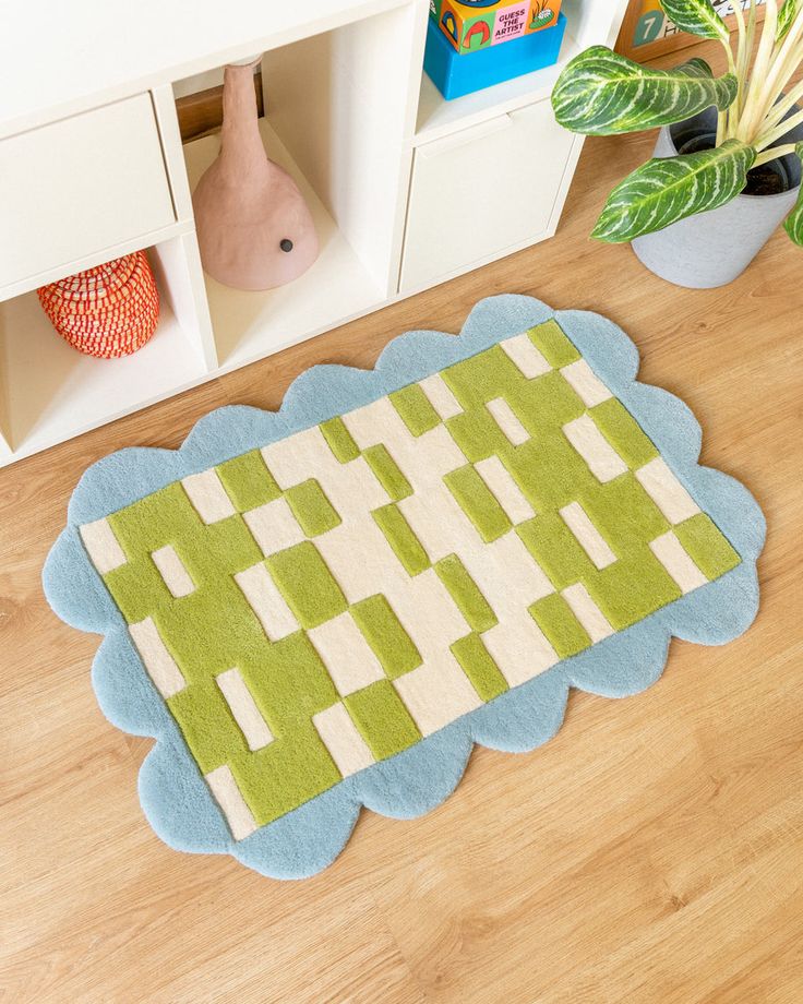 a rug on the floor in front of a bookcase with books and toys next to it