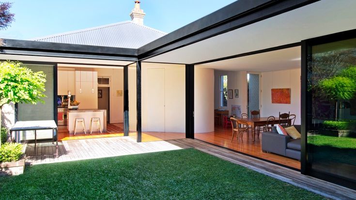 an open living room and dining area with sliding glass doors on the outside side of the house