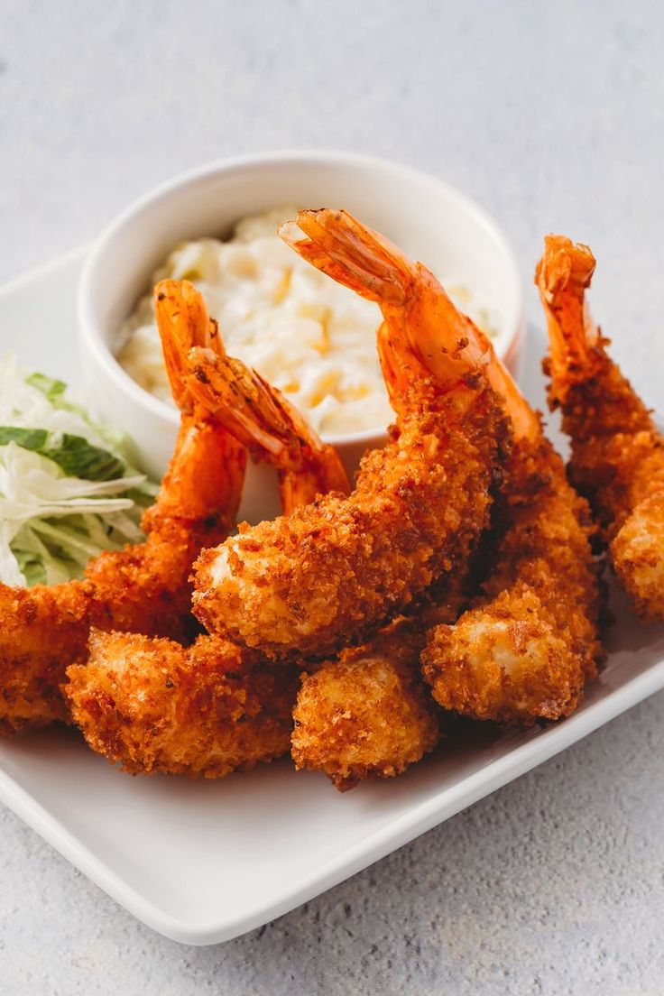 fried shrimp with cole slaw and mashed potatoes on a white square platter