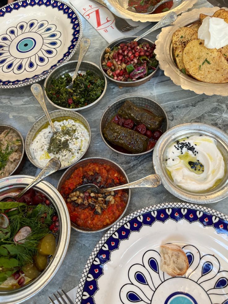 a table topped with lots of different types of food and dishes filled with sauces