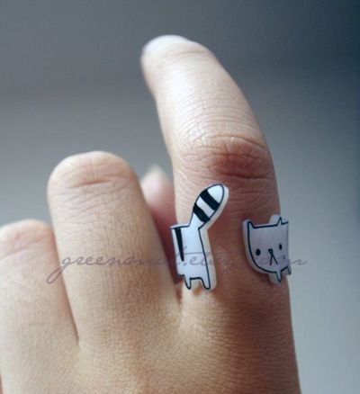 a person's hand with a cat ring on it