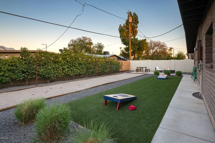 a backyard with artificial grass and a table in the middle