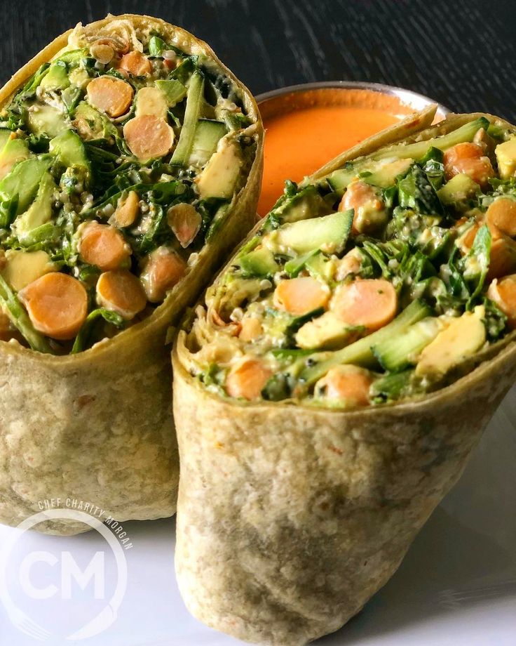 two wraps filled with vegetables and sauce on a plate