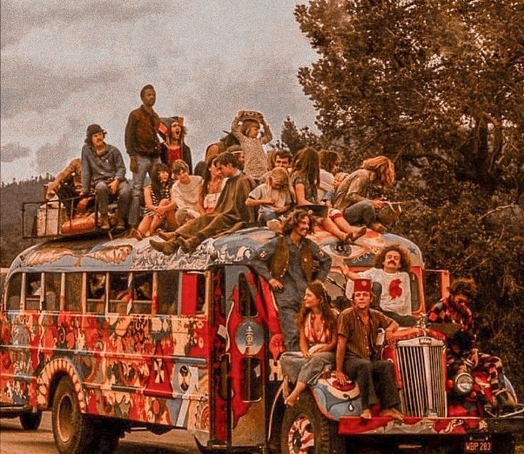 a group of people riding on the back of a bus with lots of painted walls