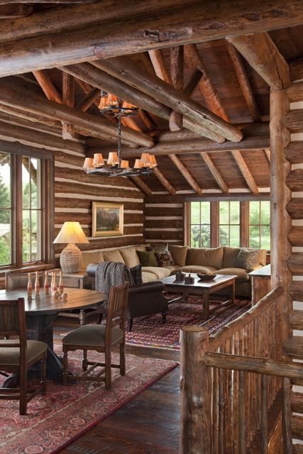 a living room filled with furniture and wooden walls