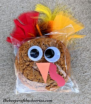 a turkey cookie in a plastic bag with fake eyes and feathers on it's head