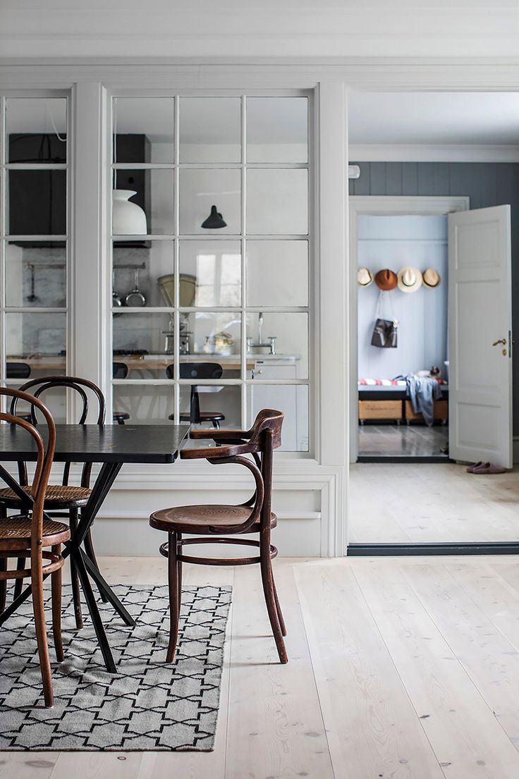 the dining room table is surrounded by chairs and glass doors that lead to an open kitchen