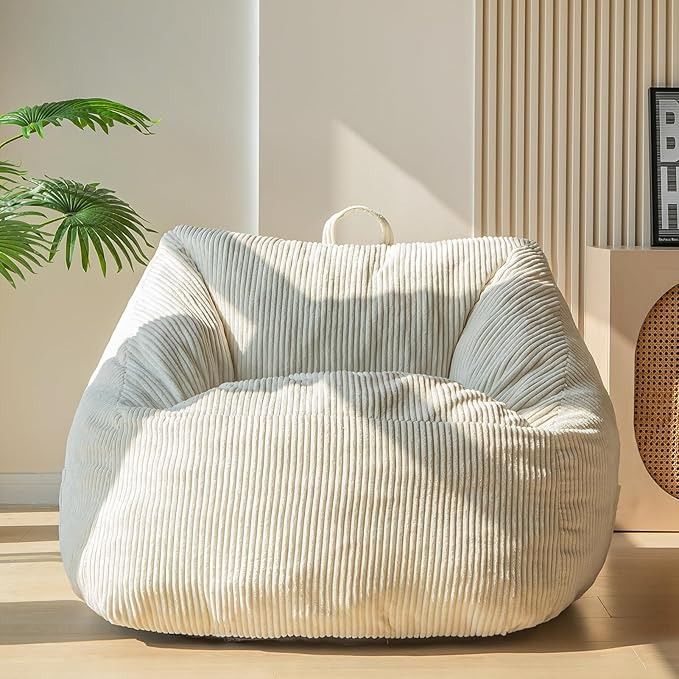 a bean bag chair sitting on top of a wooden floor next to a potted plant