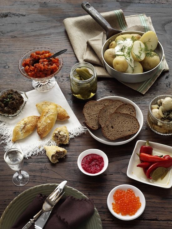 a wooden table topped with plates and bowls filled with different types of food on top of it