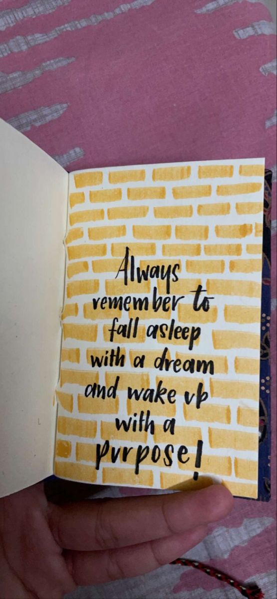 someone is holding an open book with writing on it that says, always remembers to fall asleep with a dream and wake up with a purpose