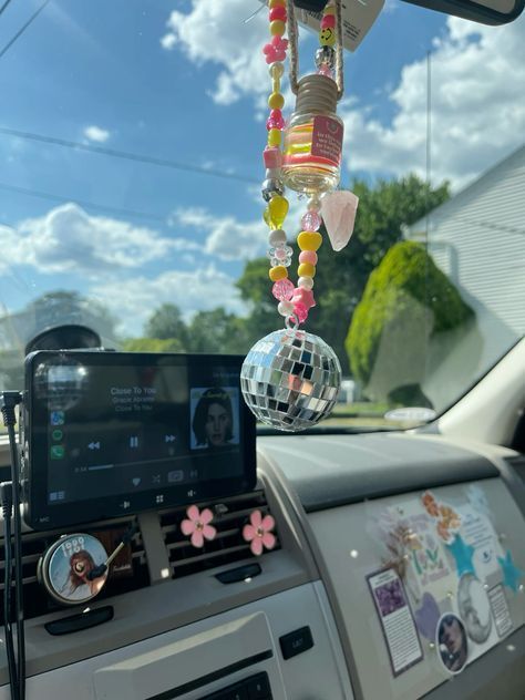 a car dashboard with a mirror ball hanging from it's ceiling and an mp3 player attached to the dash board