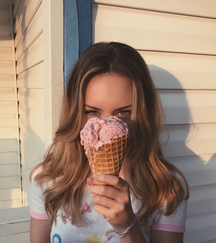 a woman holding an ice cream cone in front of her face