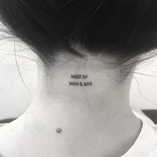 a woman's neck with the words made by mom and dad written on it