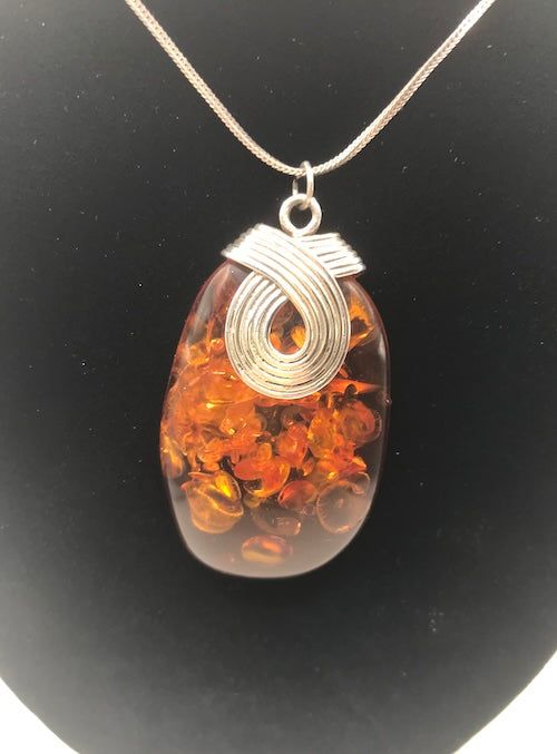 This exquisite necklace, set in sterling silver, is adorned with the finest and most valuable amber in the world - a captivating specimen originating from the Baltic Sea. Its classic Italian chain adds a touch of timeless elegance. For those seeking a jewelry piece of significance, this magnificent pendant is the perfect choice. Since antiquity, Baltic amber has been held in high regard for its unparalleled beauty, warmth, and magical luster. Sterling Silver Chain: 20" (1.25mm) sterling silver I Unique Baltic Amber Jewelry For Gifts, Unique Baltic Amber Necklace For Gift, Elegant Citrine Jewelry In Amber, Hallmarked Amber Oval Pendant Jewelry, Handmade Amber Sterling Silver Jewelry, Sterling Silver Brown Round Pendant Necklace, Brown Sterling Silver Round Pendant Necklace, Amber Oval Pendant Jewelry, Hallmarked, Baltic Amber Pendant Jewelry Gift