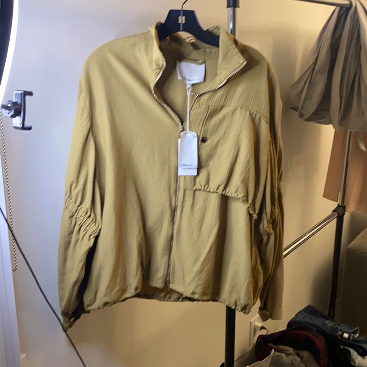 Fluid Crepe Plisse With Bungee Cord Hem And Ruched Tiered Sleeves. Olive Khaki Colored. Snap Tab Cuffs. Brand New With Tags. Never Worn. Perfect Condition. Spring Utility Windbreaker With Drawstring, Spring Utility Windbreaker For Work, Fall Long Sleeve Track Jacket With Drawstring, Fall Track Jacket With Drawstring And Long Sleeves, Spring Long Sleeve Track Jacket With Drawstring, Bungee Cord, Anorak Jacket, Khaki Color, 3.1 Phillip Lim