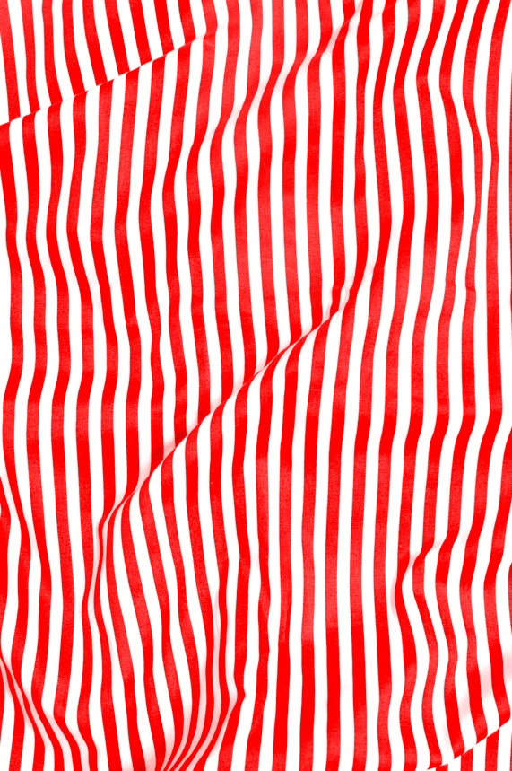 a red and white striped fabric with very thin lines on the bottom, as if it is waving in the wind