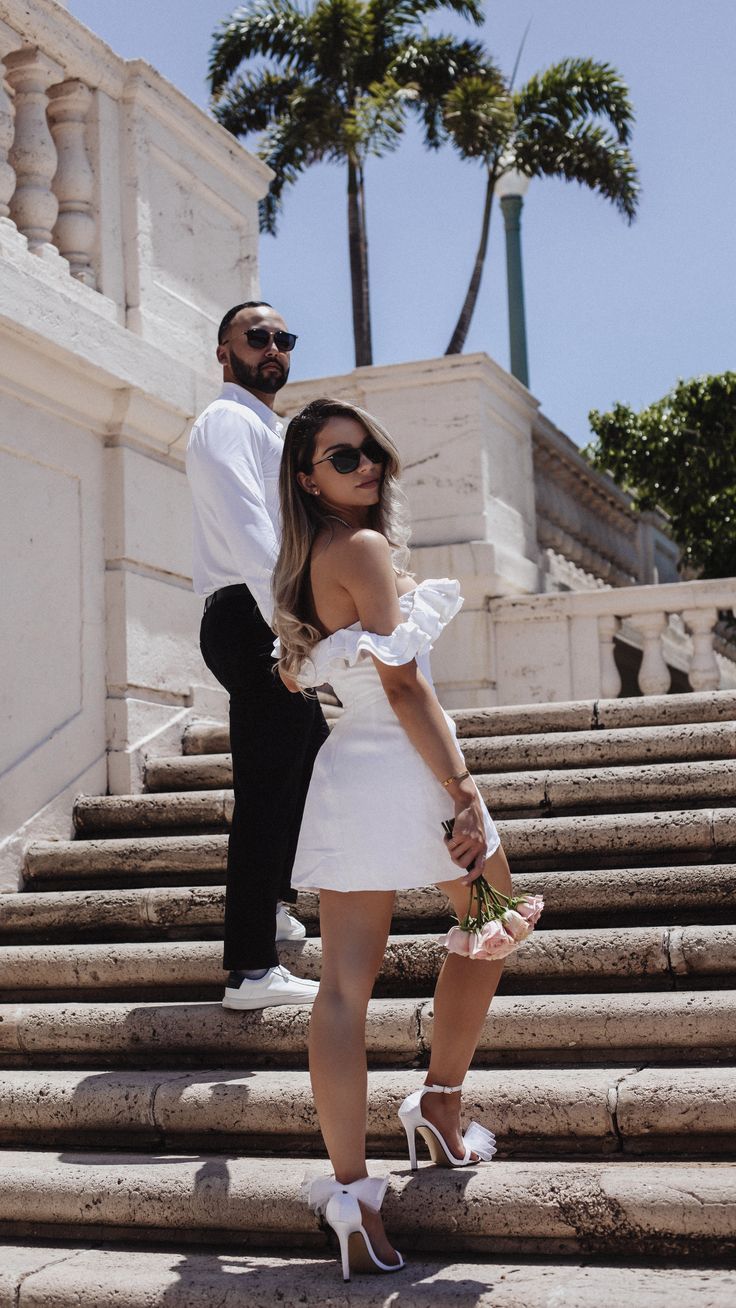 a man standing next to a woman on some steps