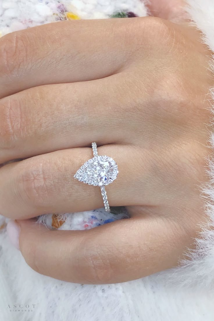 a woman's hand with a diamond ring on it