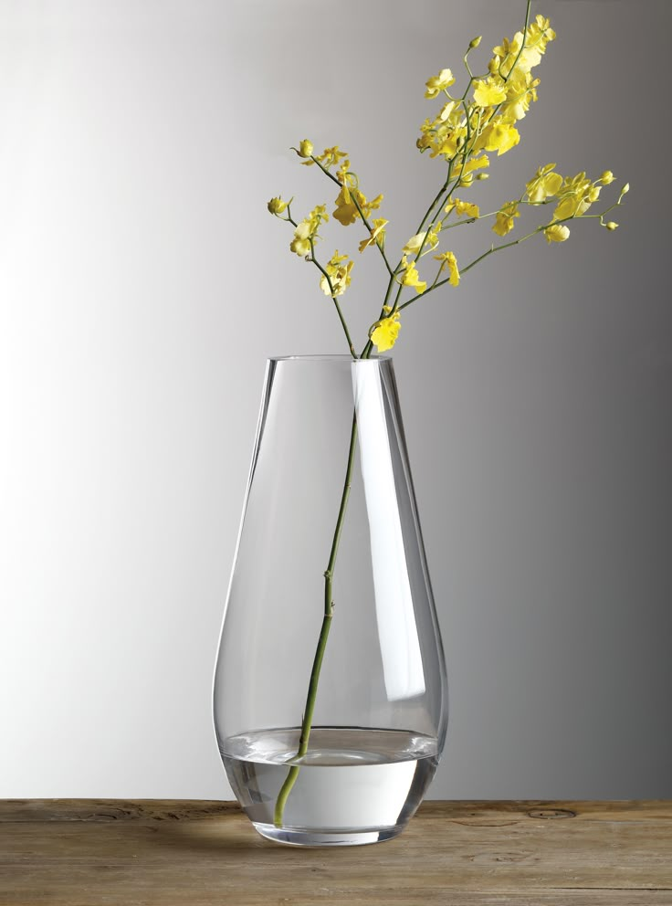 a glass vase with yellow flowers in it