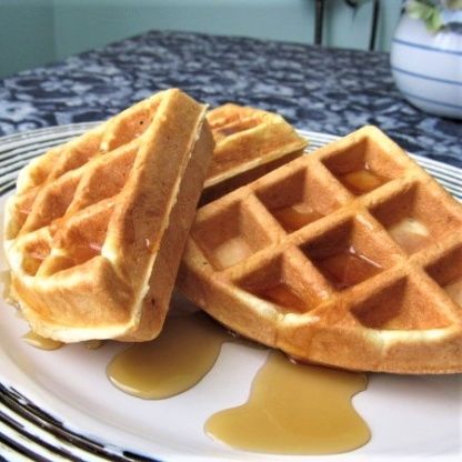 two waffles sitting on top of a white plate covered in syrup and butter