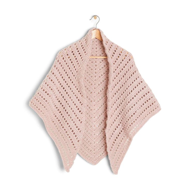 a pink knitted shawl hanging on a wooden hanger