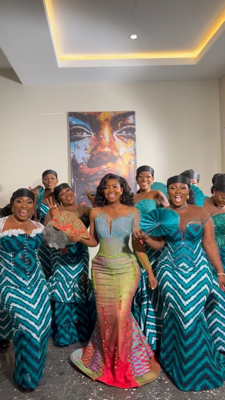 a group of women standing next to each other in front of a painting on the wall