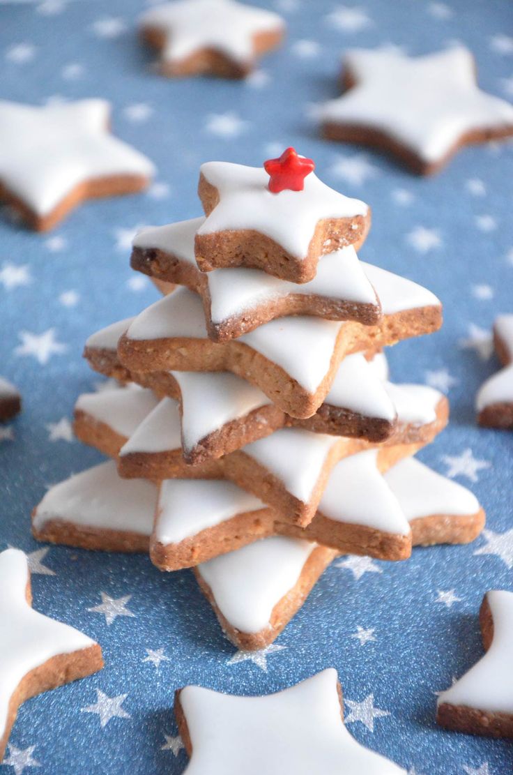 a pile of cookies with white icing and a small red star on the top