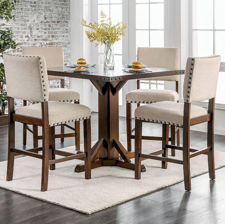 a dining room table with chairs and a rug on the floor