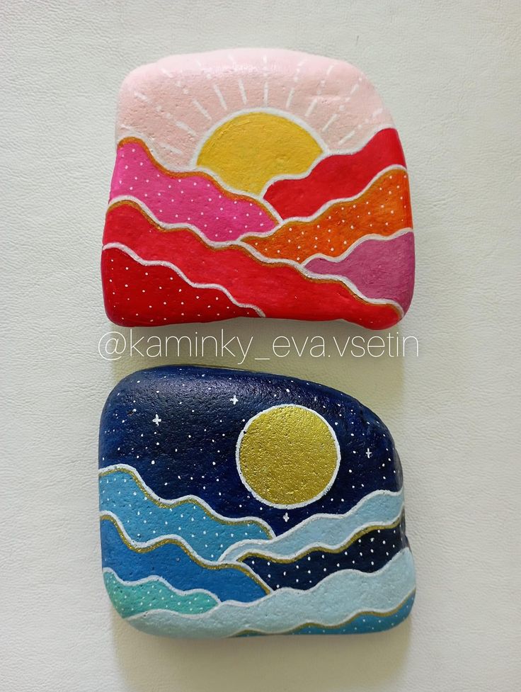 two painted rocks sitting side by side on top of each other with the sun in the sky above them