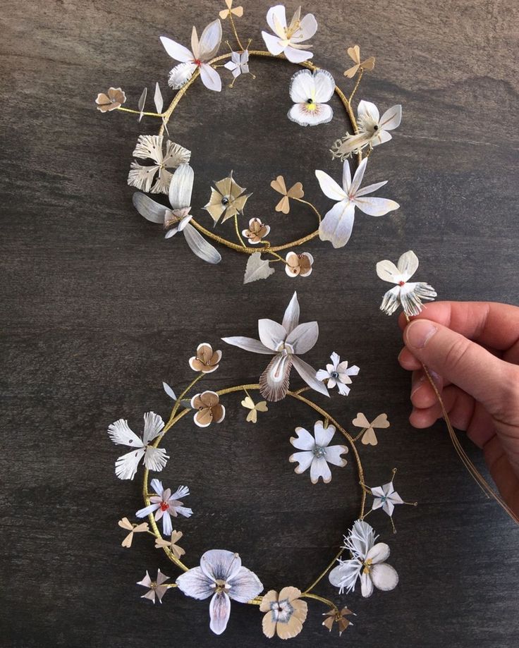 someone is making a flower crown out of wood and paper flowers on top of each other