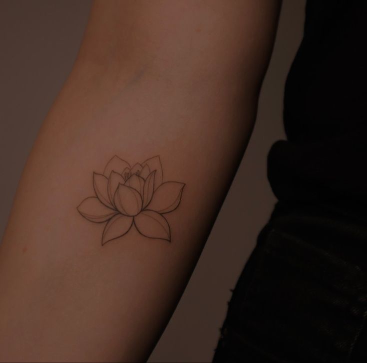 a woman's arm with a tattoo on it that has a flower in the center