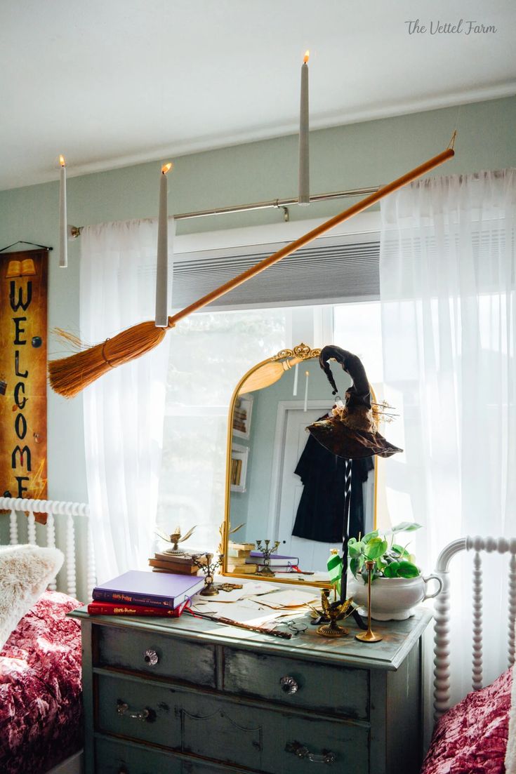 a room with a bed, dresser and mirror on it's side table in front of a window