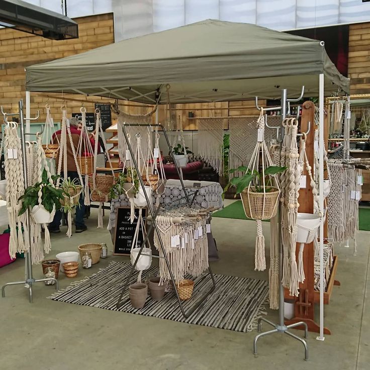 several hammocks are hanging on poles in an outdoor area with potted plants