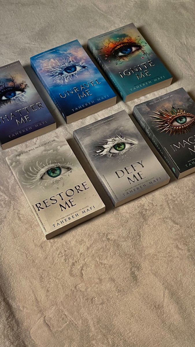 five books are laid out on a bed with the covers pulled back to reveal them