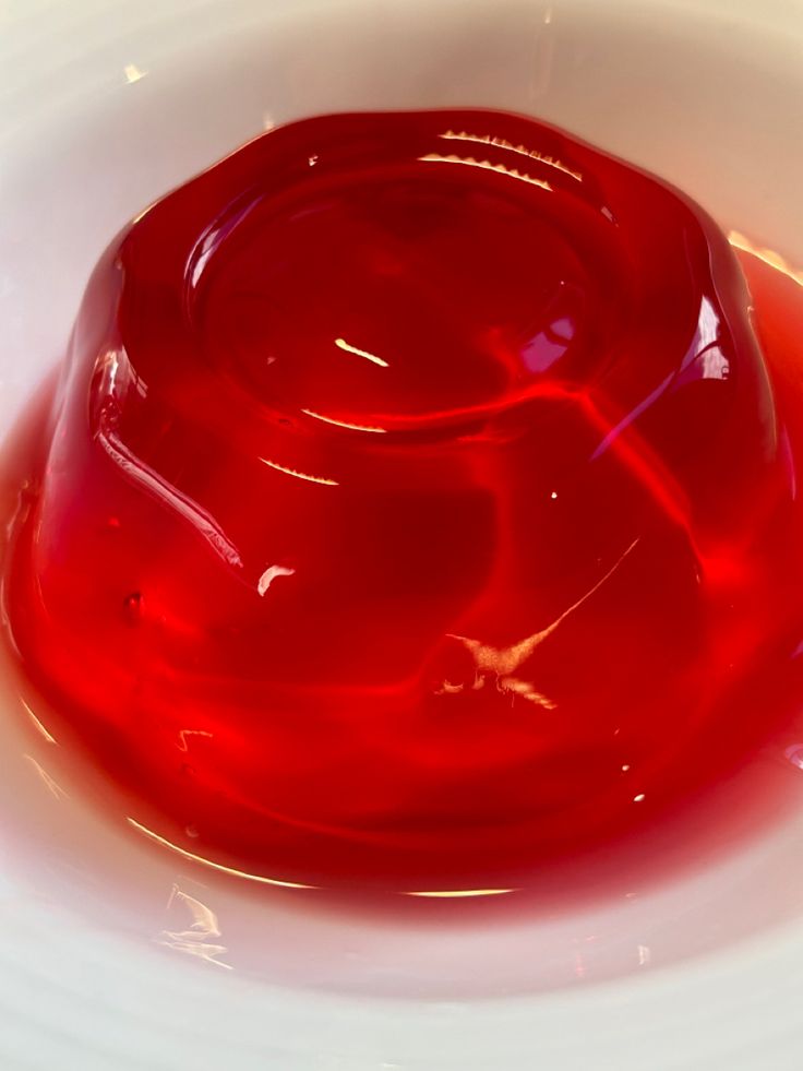 a red liquid in a white bowl on a table