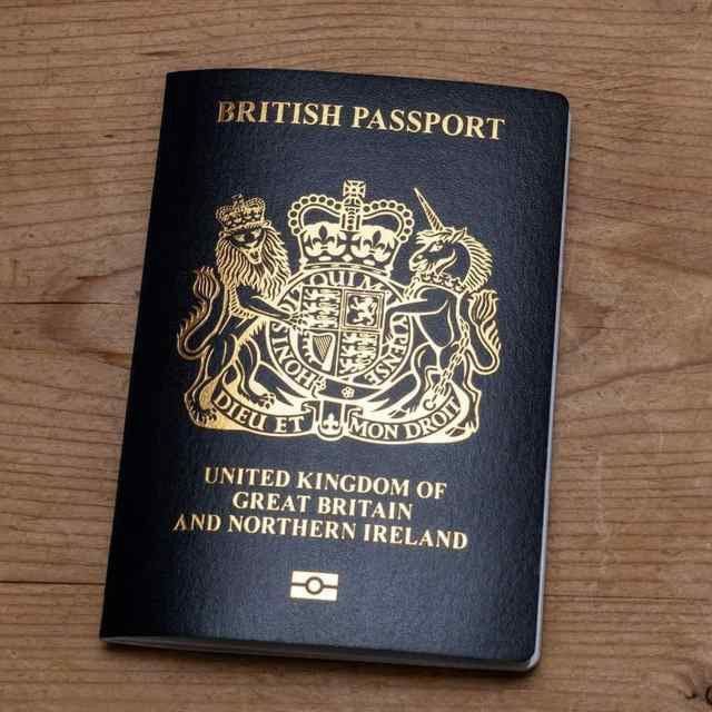 a british passport sitting on top of a wooden table