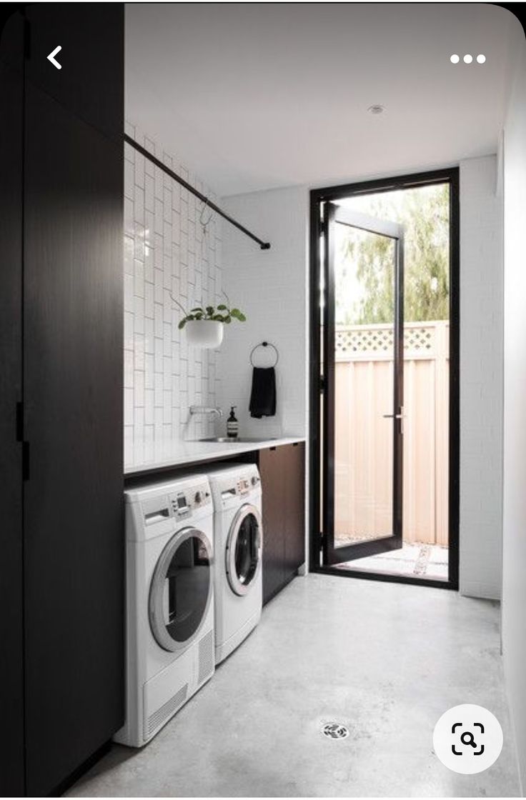 a washer and dryer in a small room next to a sliding glass door