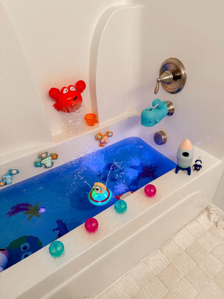 a bathtub with toys in it and water running down the side