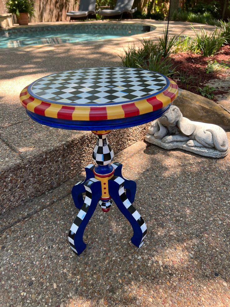 a table with a checkerboard design on it sitting in front of a pool