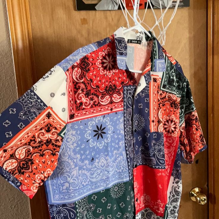 a colorful shirt hanging on a door with a basketball hoop in the corner behind it