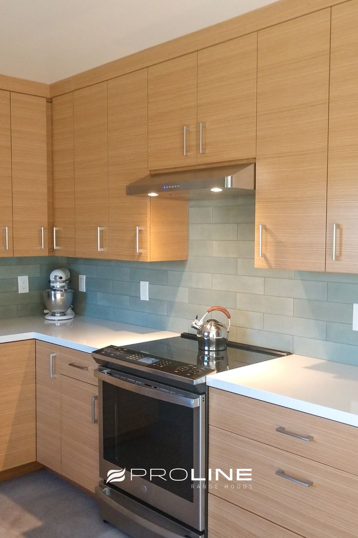 an empty kitchen with wooden cabinets and stainless steel stove top oven, dishwasher and microwave