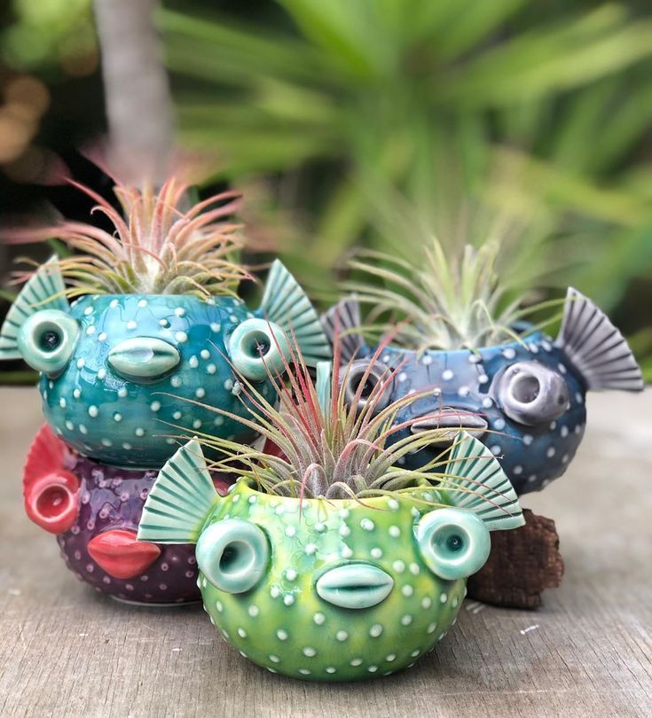 three ceramic fish planters sitting on top of a wooden table