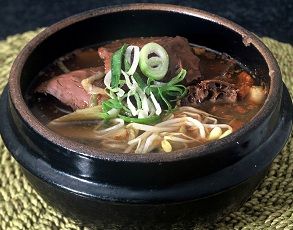 a bowl filled with soup and noodles on top of a table