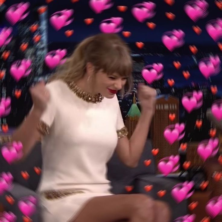 taylor swift is sitting on a couch with hearts all over her body and hands in the air