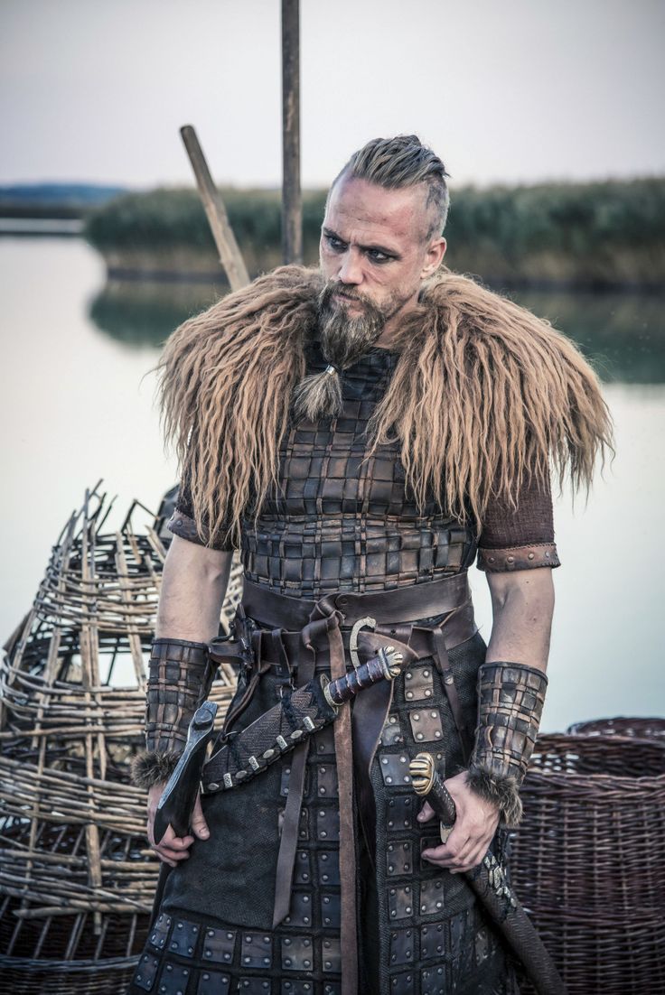 a man in armor standing next to a body of water