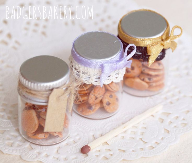 three jars filled with cookies on top of a doily